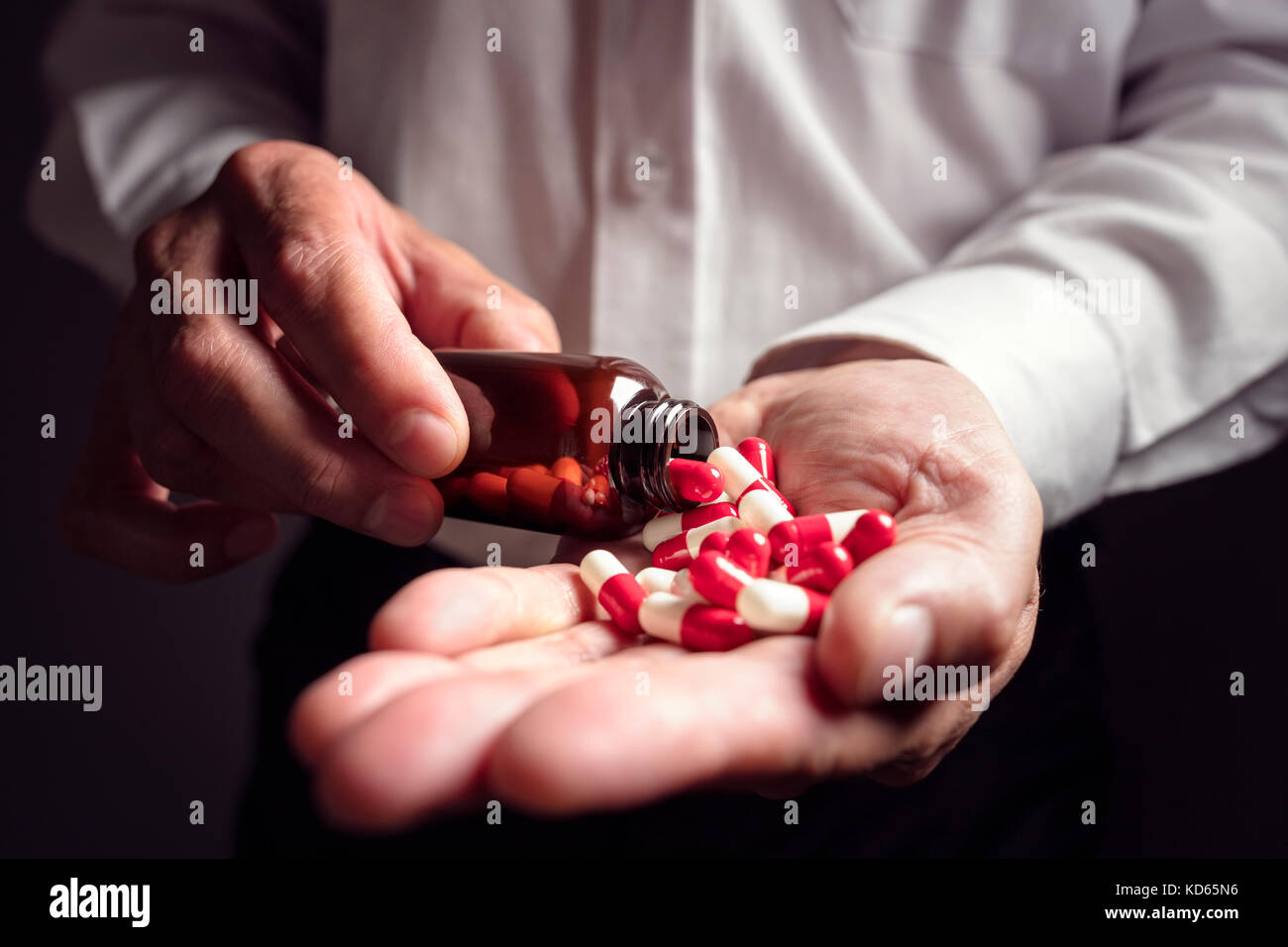 Versando la prescrizione di farmaci capsule da una pillola bottiglia in mano Foto Stock