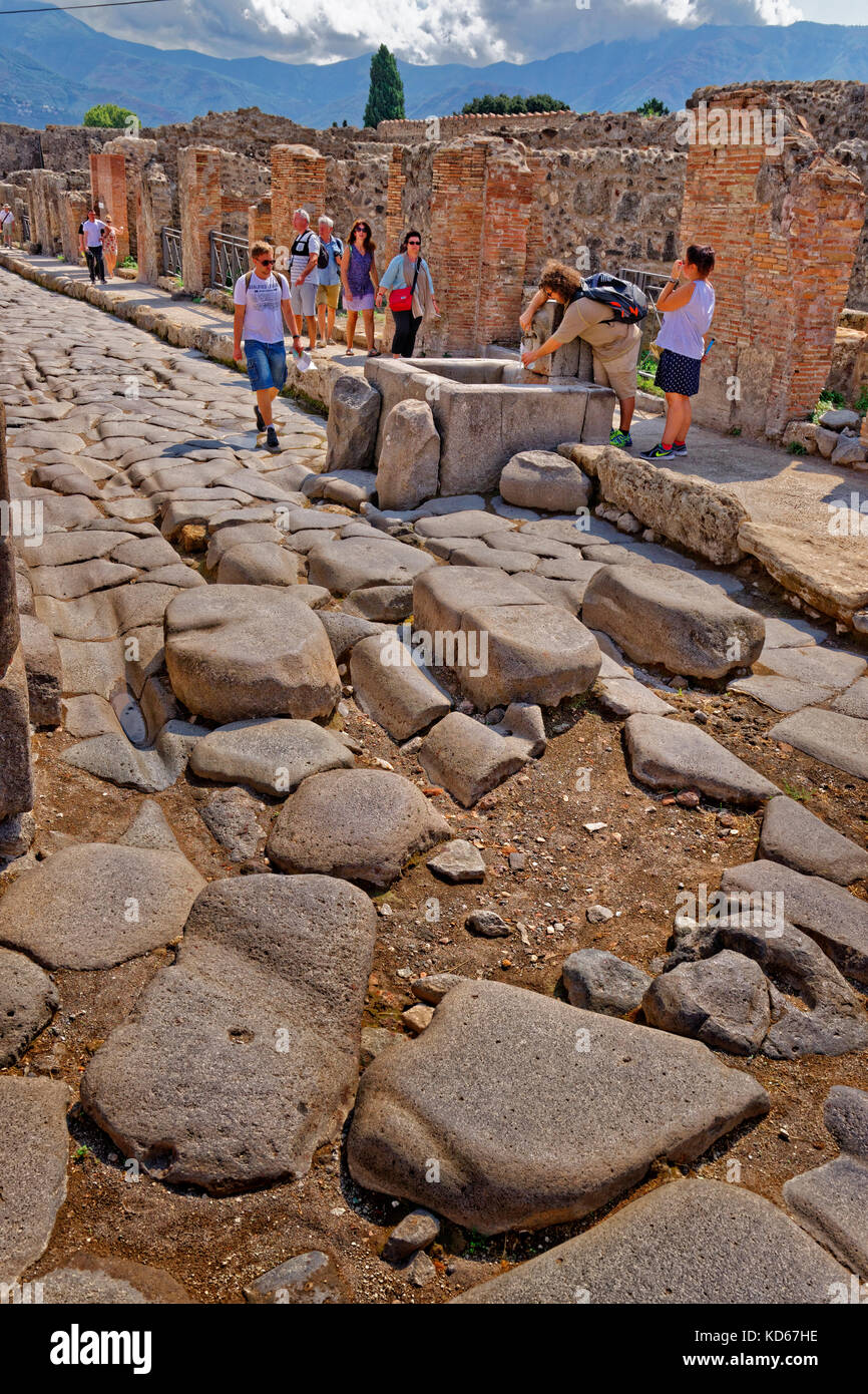 Strada con acqua comunale font con le rovine di una città romana di Pompei a Pompei Scavi, vicino napoli, Italia meridionale. Foto Stock