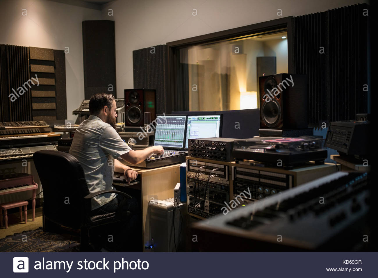 Maschio produttore musicale lavorando al computer in studio di registrazione Foto Stock