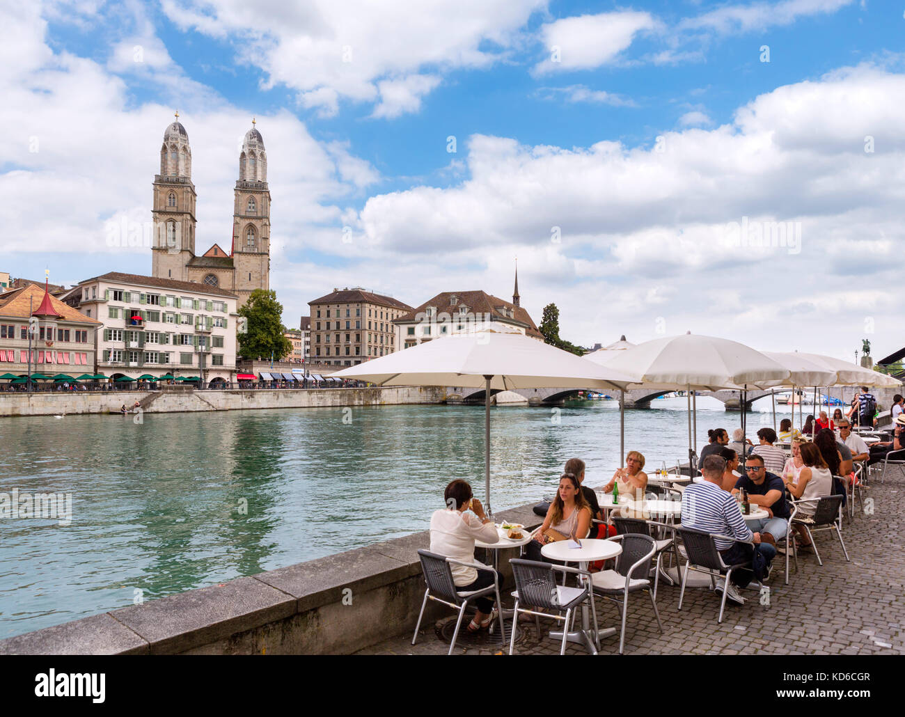 Cafe sulle rive del fiume Limmat guardando verso il Grossmünster, Zurigo, il lago di Zurigo, Svizzera Foto Stock