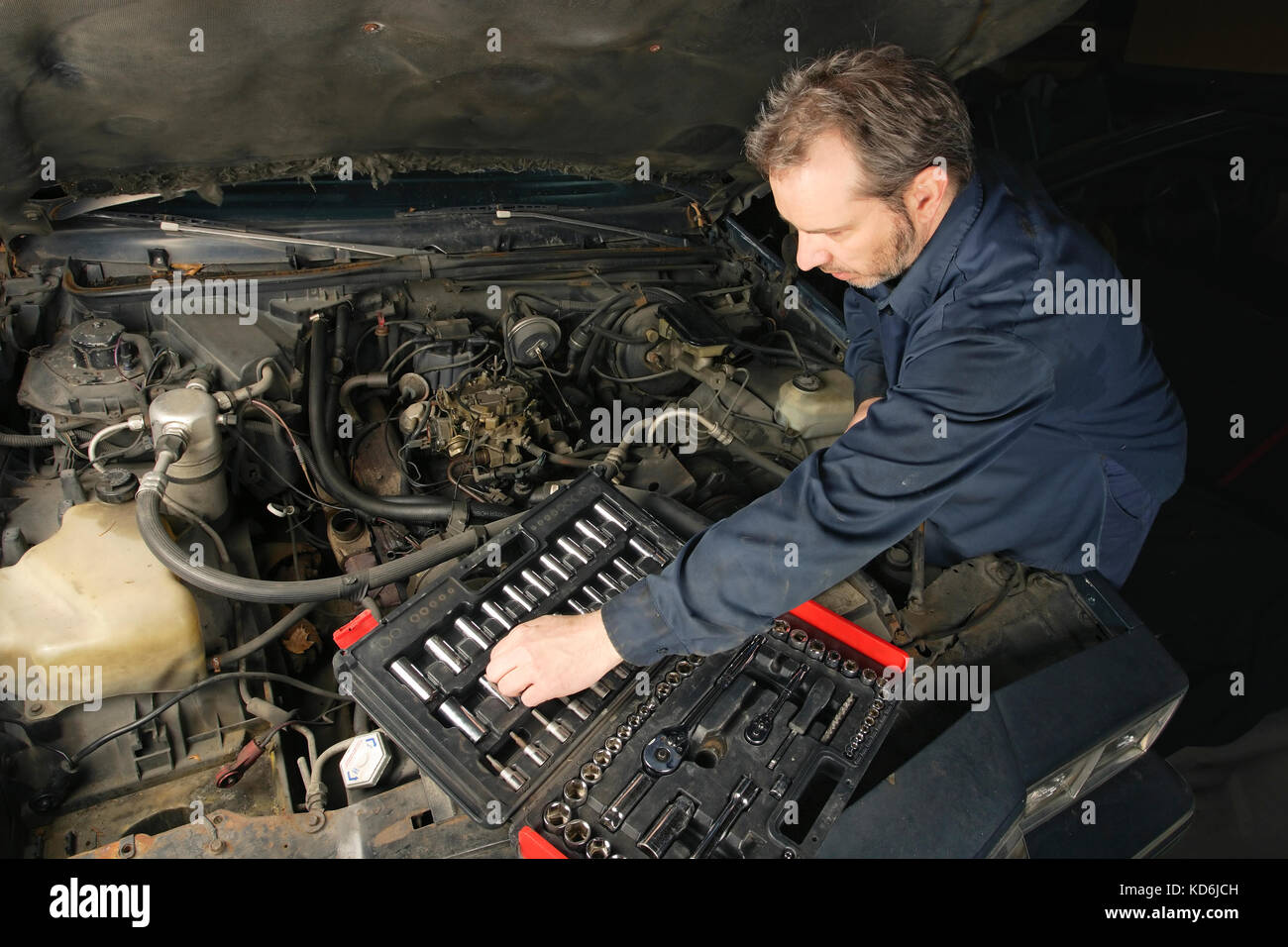 Foto di un meccanico di riparazione di un motore di una vecchia auto. Foto Stock