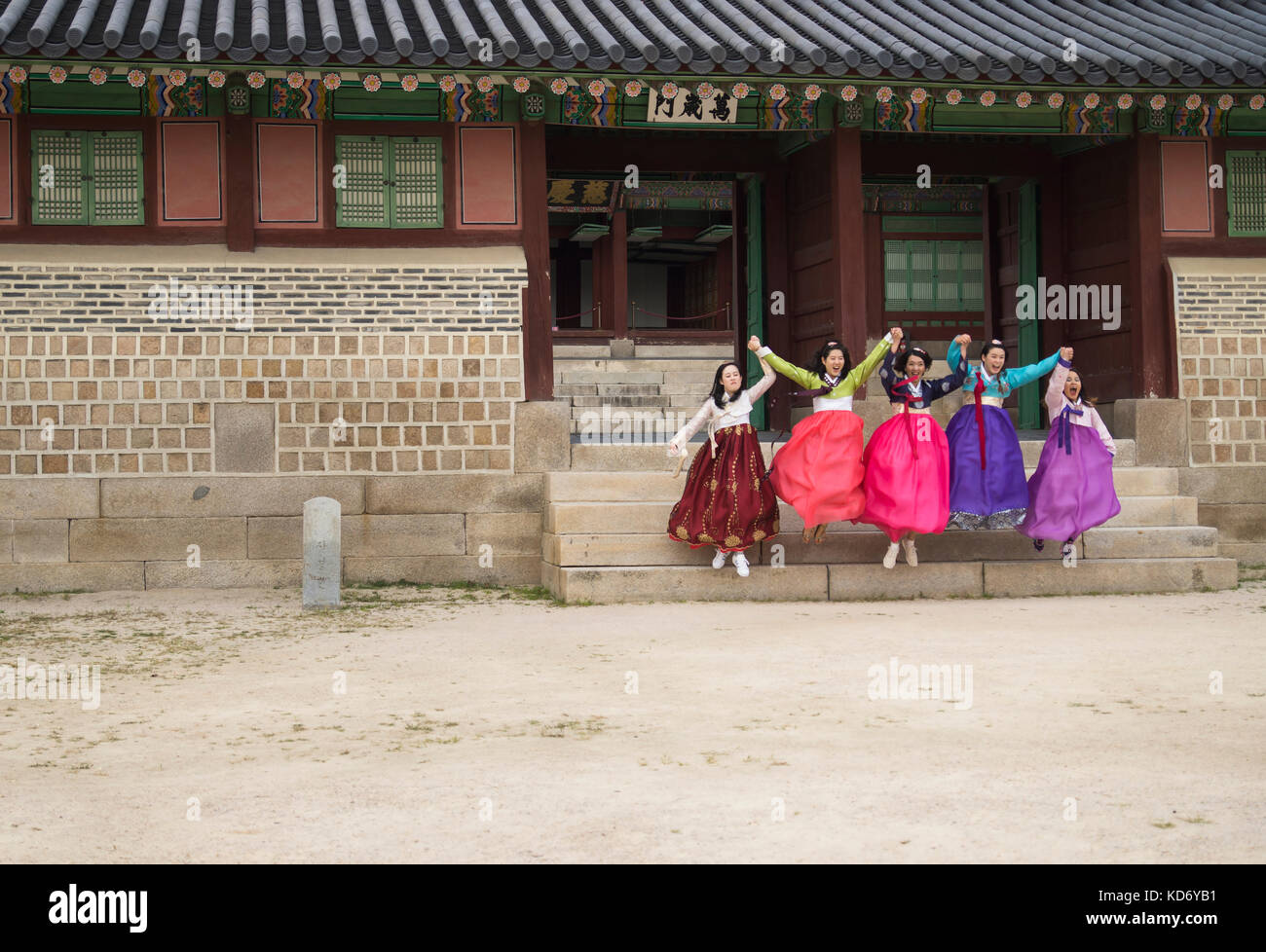 Seoul, Corea del Sud - 4 settembre 2017: Cinque donne turistiche coreane in abiti Hanok colorati tradizionali saltano dalle scale di un edificio a Gyeon Foto Stock