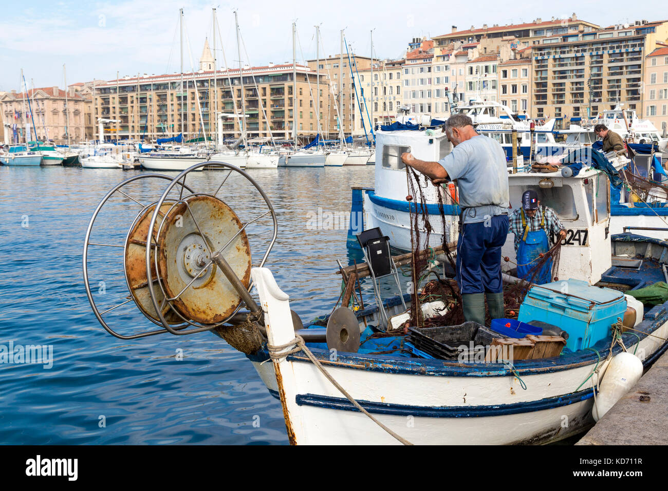Fisherman tirando il pesce al di fuori della rete in Vieux Port (porto vecchio) sul giorno di mercato, Marsiglia, Francia Foto Stock