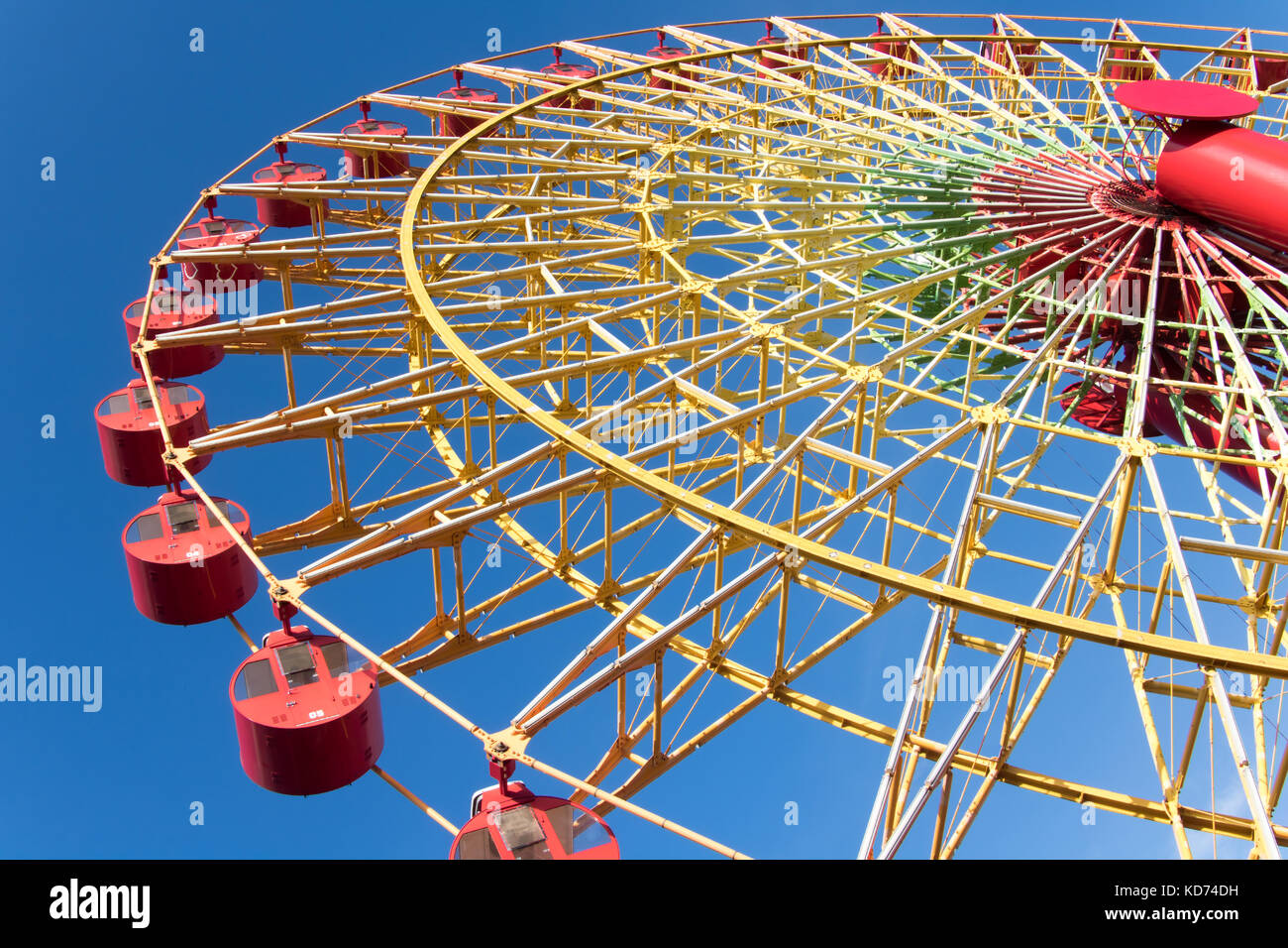 Ruota panoramica con cabine rosso ruotare contro il cielo blu. Foto Stock