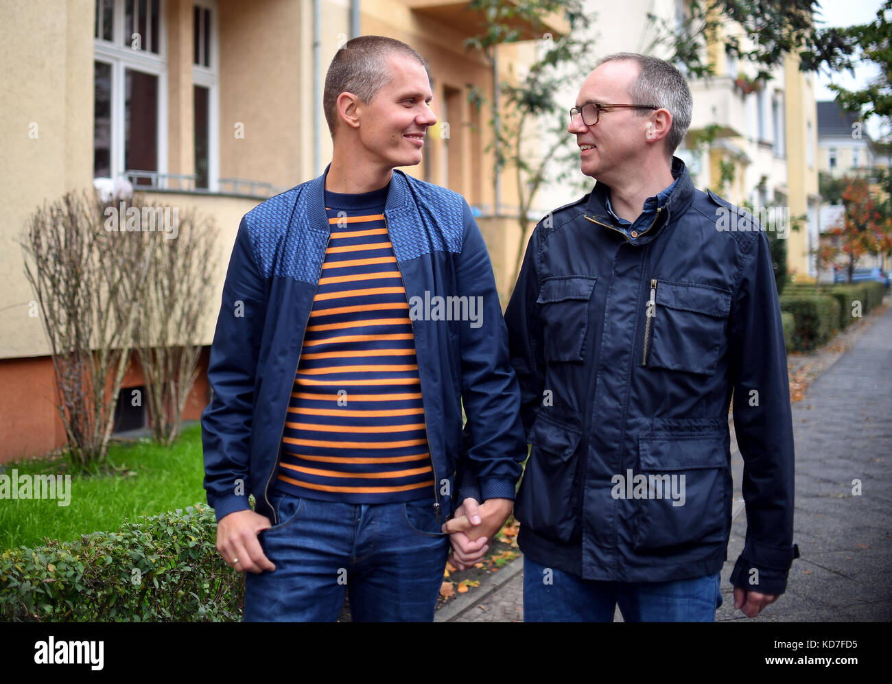 Berlino, Germania. 10 ottobre 2017. Michael e Kai Korok camminano lungo una strada a Berlino, Germania, 10 ottobre 2017. La coppia gay ha vinto il diritto di adottare un bambino dopo decenni di attesa. Sono la prima coppia a Berlino ad adottare un bambino. La decisione è stata presa solo dieci giorni dopo che il diritto al matrimonio gay è stato approvato dal parlamento tedesco. Crediti: Britta Pedersen/dpa-Zentralbild/dpa/Alamy Live News Foto Stock