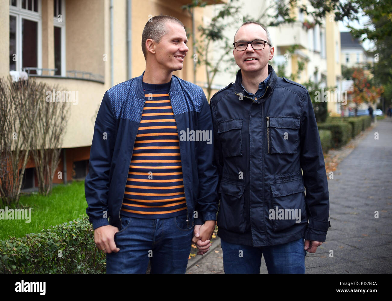 Berlino, Germania. 10 ottobre 2017. Michael e Kai Korok camminano lungo una strada a Berlino, Germania, 10 ottobre 2017. La coppia gay ha vinto il diritto di adottare un bambino dopo decenni di attesa. Sono la prima coppia a Berlino ad adottare un bambino. La decisione è stata presa solo dieci giorni dopo che il diritto al matrimonio gay è stato approvato dal parlamento tedesco. Crediti: Britta Pedersen/dpa-Zentralbild/dpa/Alamy Live News Foto Stock