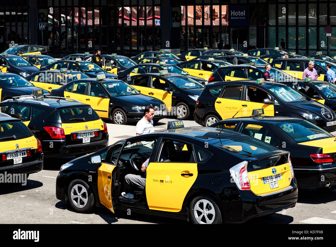 BARCELLONA, SPAGNA - 17 APRILE 2013: Viaggiatori e numerosi taxi attendono di fronte alla stazione ferroviaria di Barcelona-Sants il 17 aprile Foto Stock