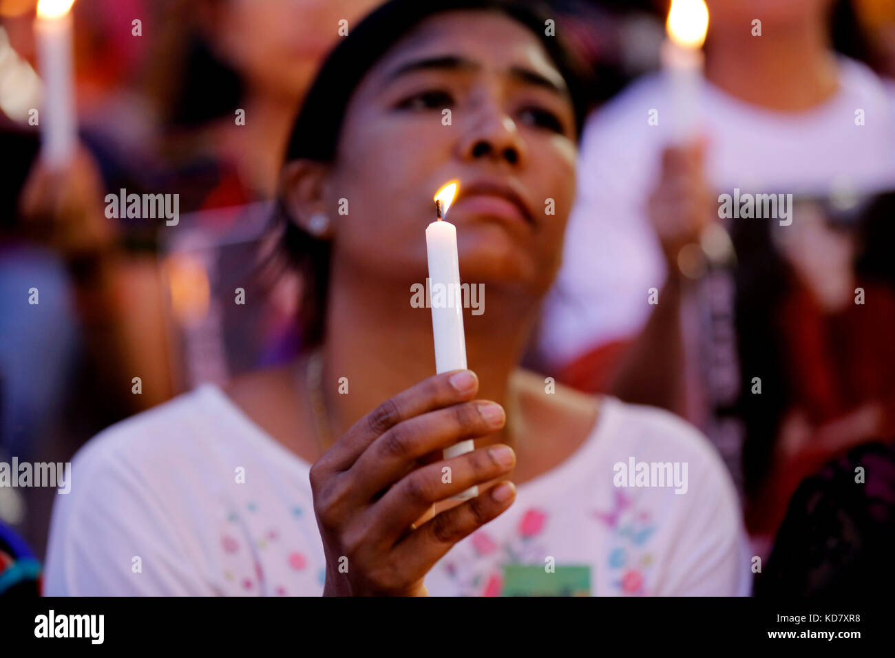 Yangon, Myanmar. Decimo oct, 2017. Una donna che tiene in mano una candela come ella prega durante l'inter-fede raccolta di preghiere per la pace cerimonia di Aung San stadium di Yangon, myanmar, oct. 10, 2017. persone di fedi diverse in Myanmar ha tenuto una preghiera di massa cerimonia in Yangon fine martedì per la prima volta a pregare per l'amicizia e la pace volto ad alleviare i conflitti nel paese del nord di Stato di Rakhine. Credito: u aung/xinhua/alamy live news Foto Stock