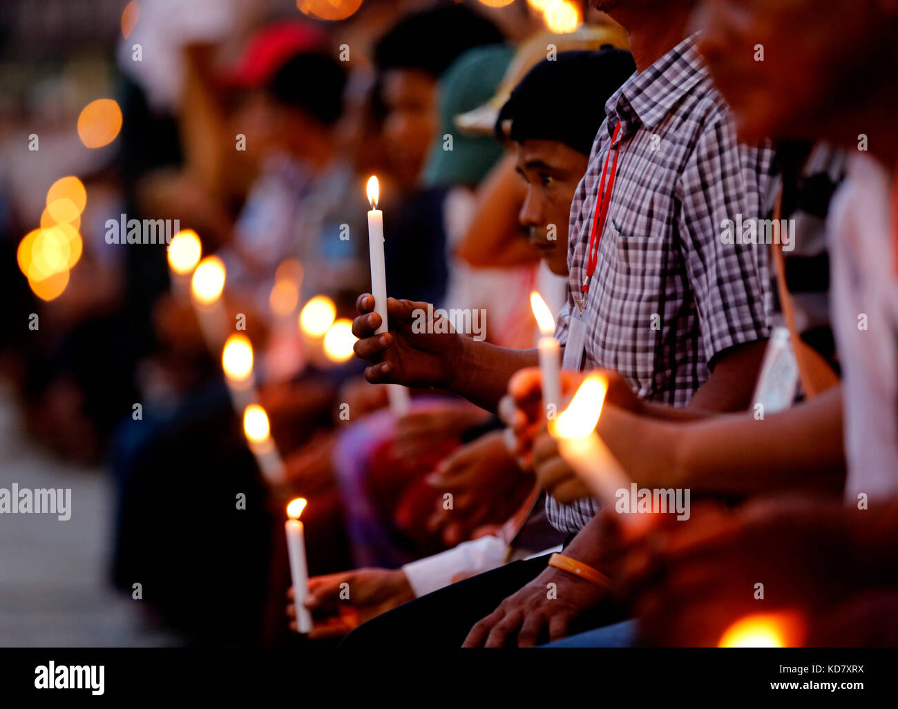 Yangon, Myanmar. 10 ottobre 2017. Le persone tengono le candele mentre pregano durante l'incontro interreligioso delle preghiere per la cerimonia di pace allo stadio Aung San di Yangon, Myanmar, 10 ottobre 2017. Le persone con diverse fedi in Myanmar hanno tenuto una cerimonia di preghiera di massa a Yangon martedì tardi per la prima volta per pregare per l'amicizia e la pace volte ad alleviare i conflitti nello stato settentrionale di Rakhine del paese. Crediti: U Aung/Xinhua/Alamy Live News Foto Stock