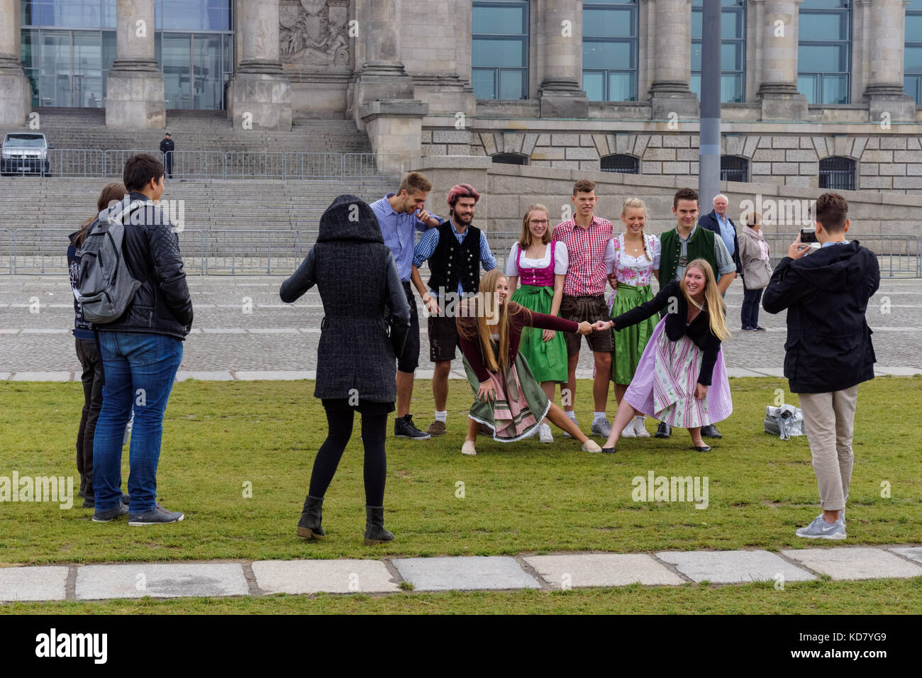 Giovani tedeschi prendendo foto davanti al palazzo di Reichstag a Berlino, Germania Foto Stock