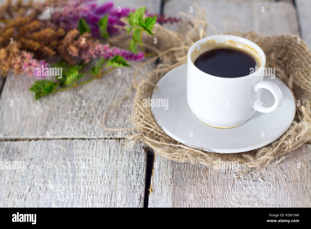 Tazza da caffè con fiori di buona mattina su bianco tavolo rustico Foto Stock