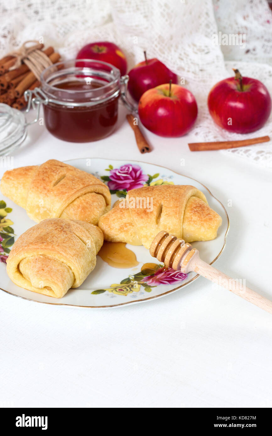 La prima colazione. croissant, miele e apple su whote sfondo di legno. prima colazione italiana. Il cibo gustoso. prodotti da forno. Foto Stock