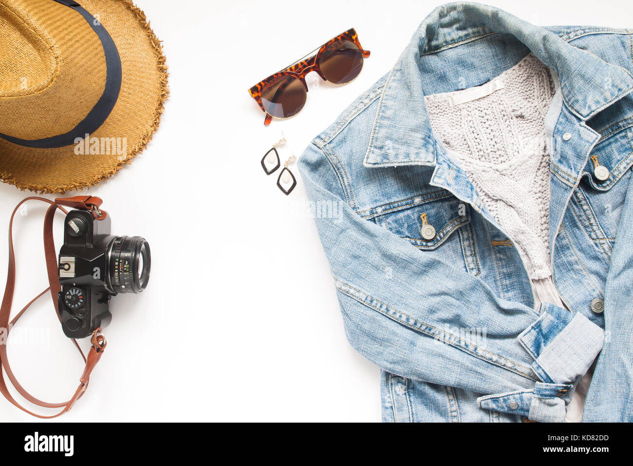 Creative laici piana di articoli da viaggio con fotocamera e giacca donna jeans su sfondo bianco Foto Stock