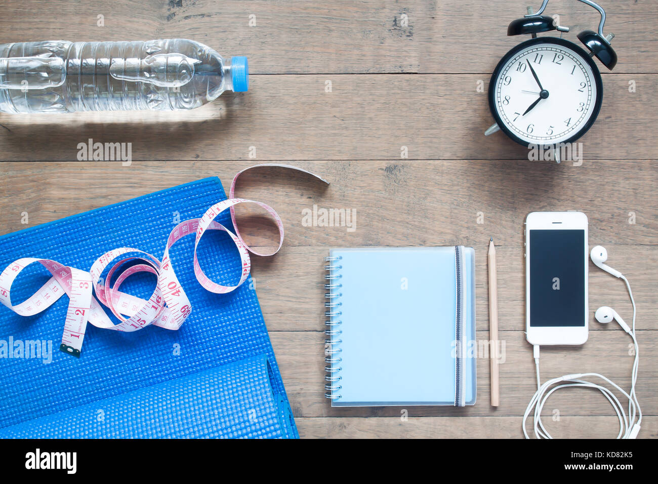 Palestra e fitness concetto con notebook, smartphone e sveglia su sfondo di legno Foto Stock