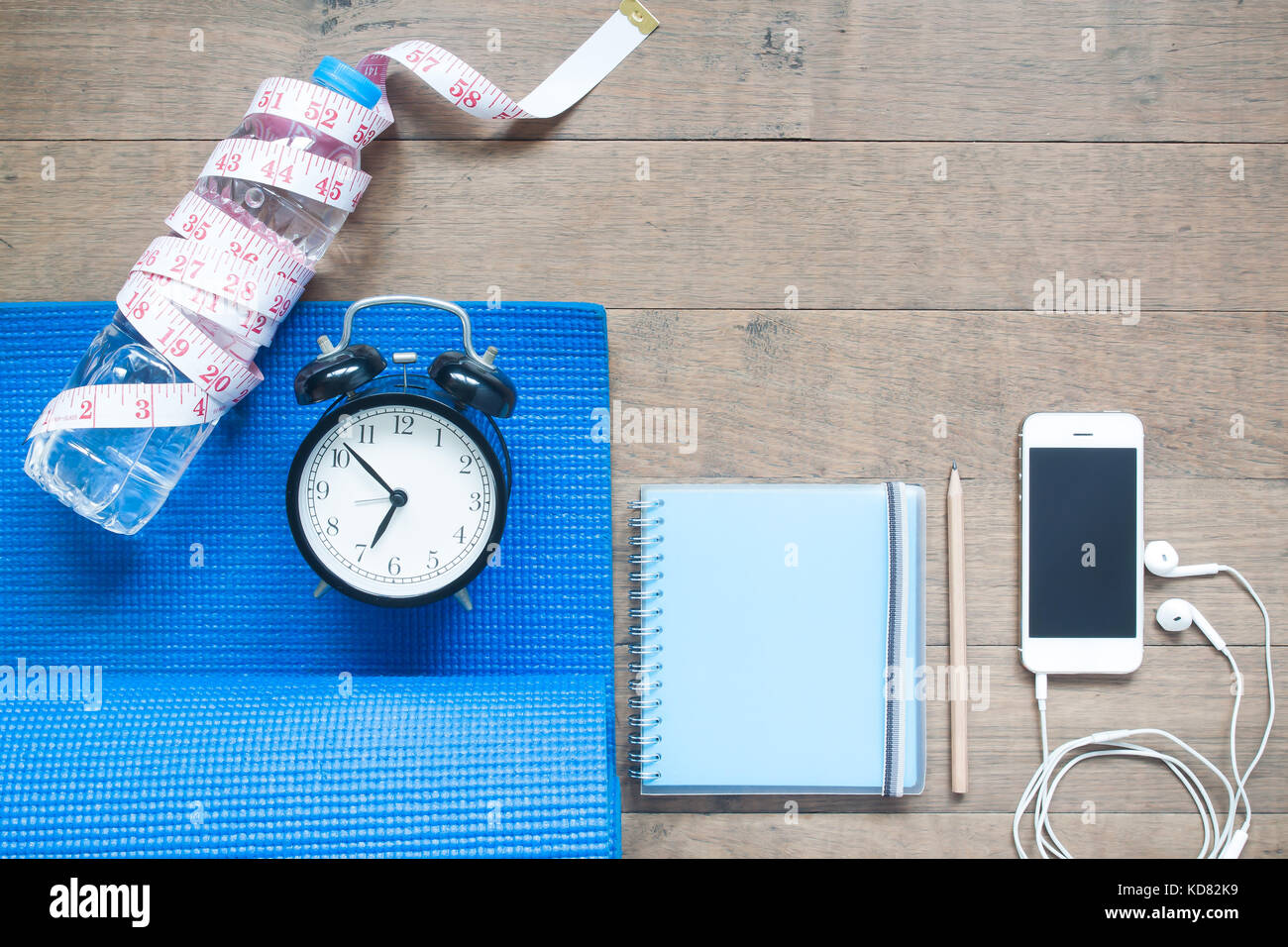Fitness e il concetto di dieta con notebook, smartphone e sveglia su sfondo di legno Foto Stock