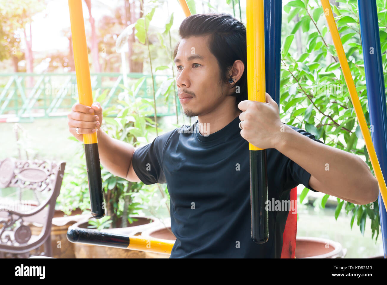 Uomo asiatico esercitando con attrezzature di formazione presso il Park, uno stile di vita sano Foto Stock