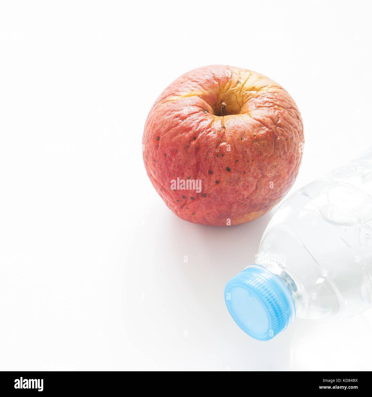 Health care concetto con imbarazzo apple e bottiglia di acqua su sfondo bianco Foto Stock
