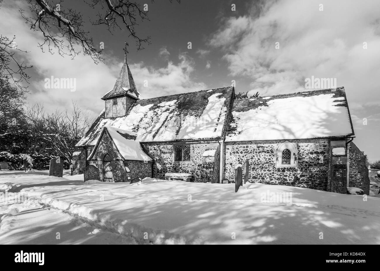 Chiesa di San Nicola, Pyrford, Surrey, Regno Unito con una copertura di neve in inverno, in bianco e nero Foto Stock