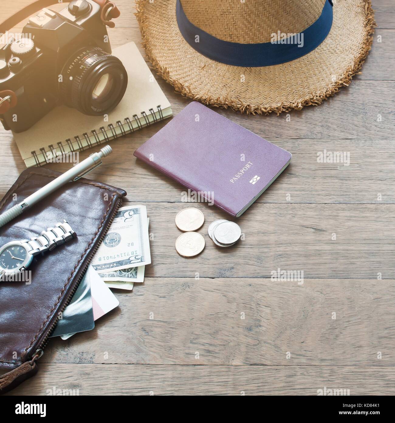 Traveler's accessori essenziali elementi di vacanza del giovane con passaporto, fotocamera e borsa su uno sfondo di legno con spazio di copia Foto Stock