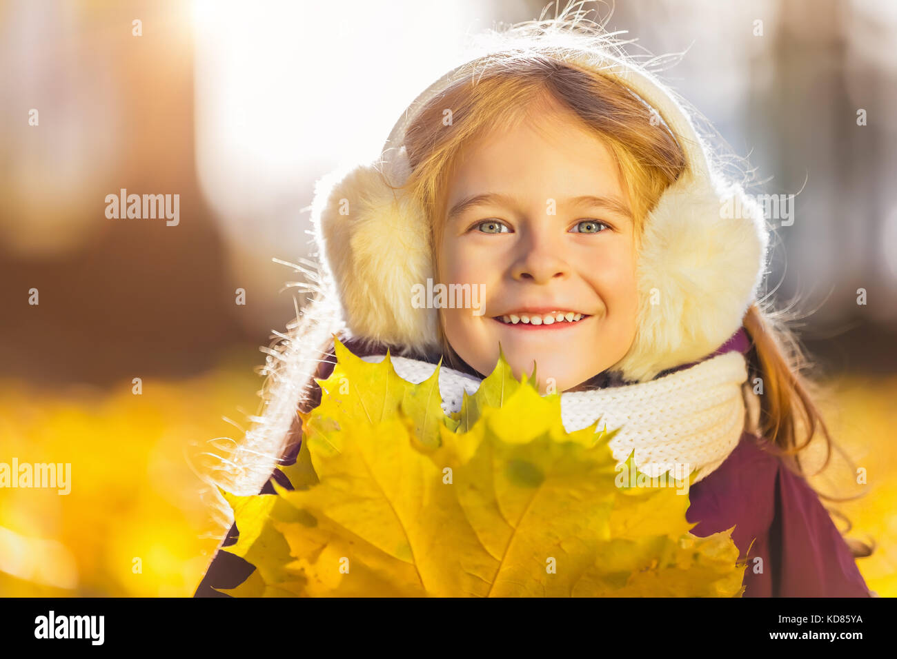 Felice bambina earflaps con foglie di autunno Foto Stock