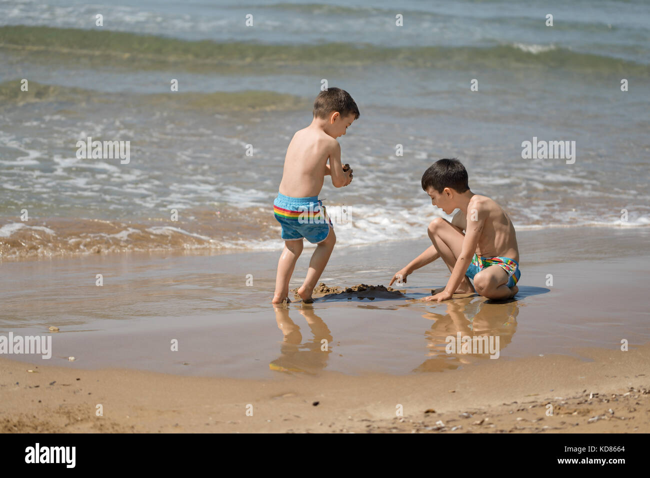 Due ragazzi che giocano sulla spiaggia, Corfù, Grecia Foto Stock