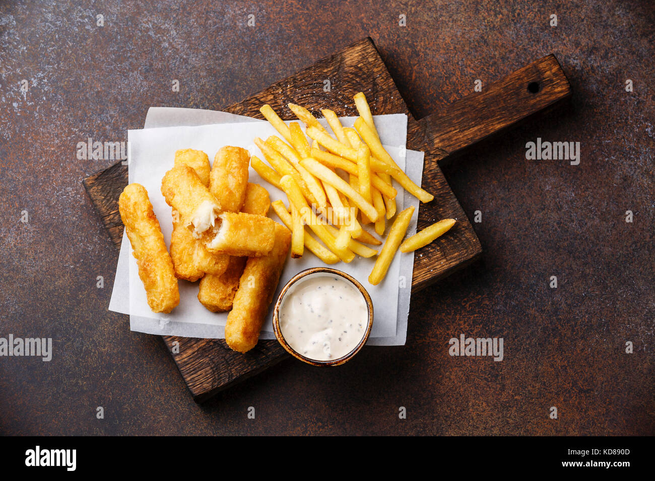 I bastoncini di pesce e patatine british fast food con salsa tartara su sfondo scuro Foto Stock