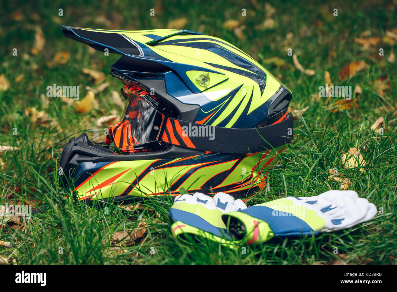 Motociclo casco con guanti e occhiali di protezione a secco caduta foglie  su greem erba. Automne Foto stock - Alamy