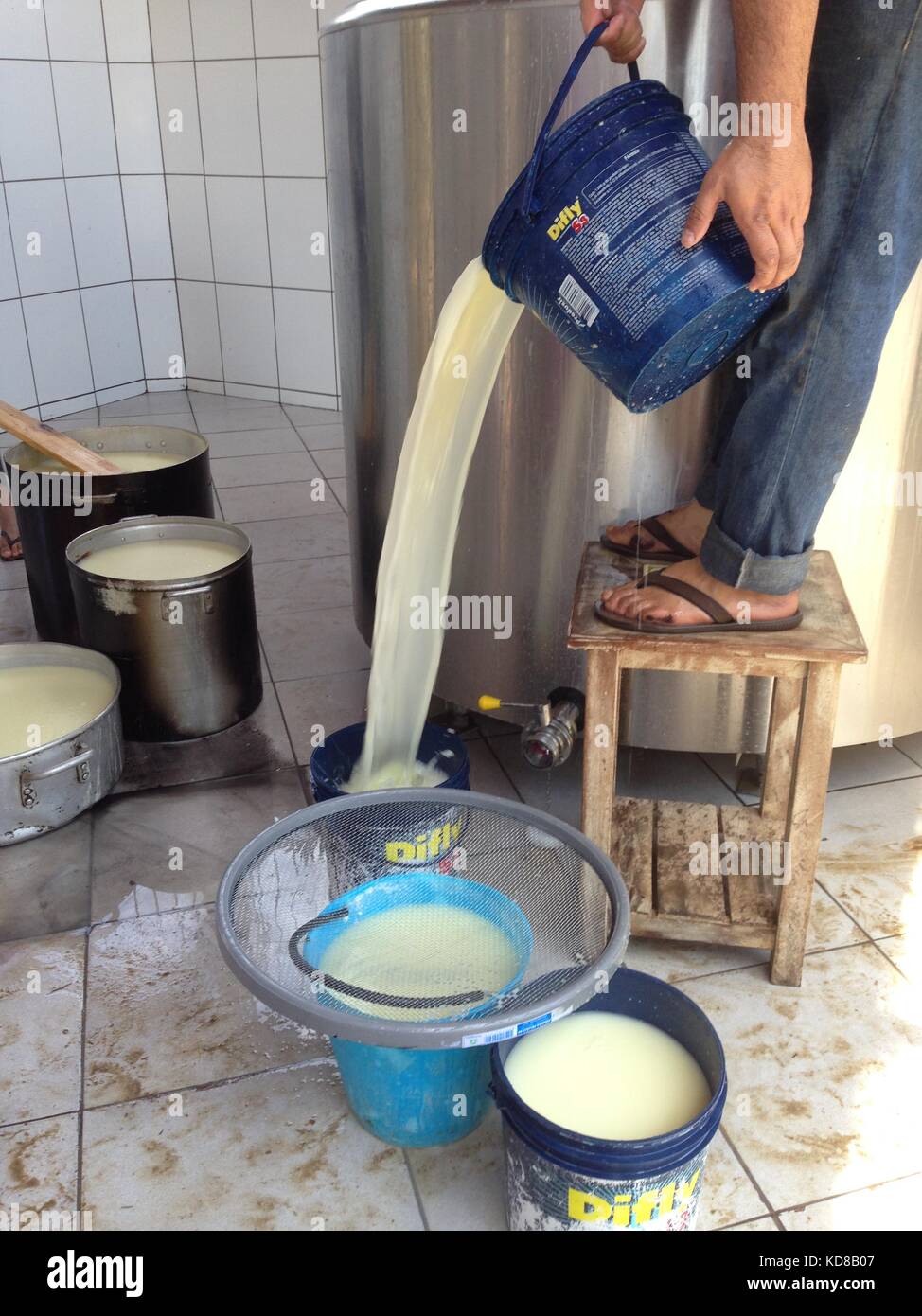 La lavorazione del formaggio in un agriturismo rustico, il drenaggio del siero di latte Foto Stock