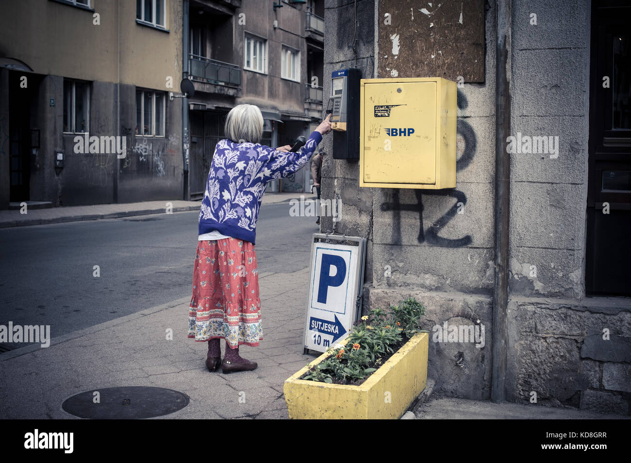 Une personne agée utilizzare le téléphone pubblico à Sarajevo en mai 2015. Una vecchia signora usa il telefono pubblico a Sarajevo, maggio 2015. Foto Stock