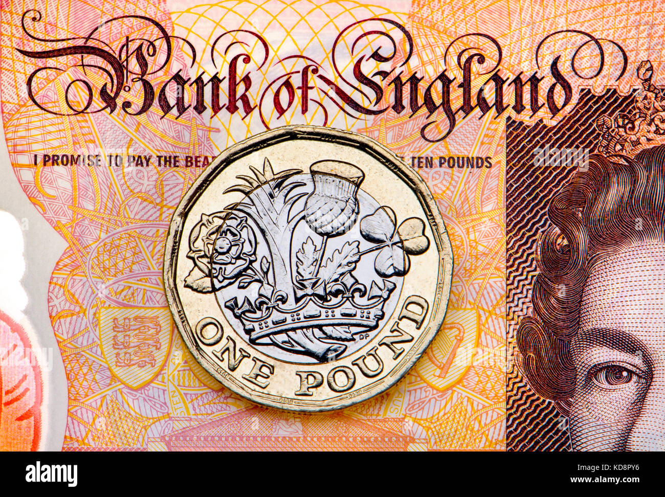 New British pound coin su un plastice £10 nota Foto Stock