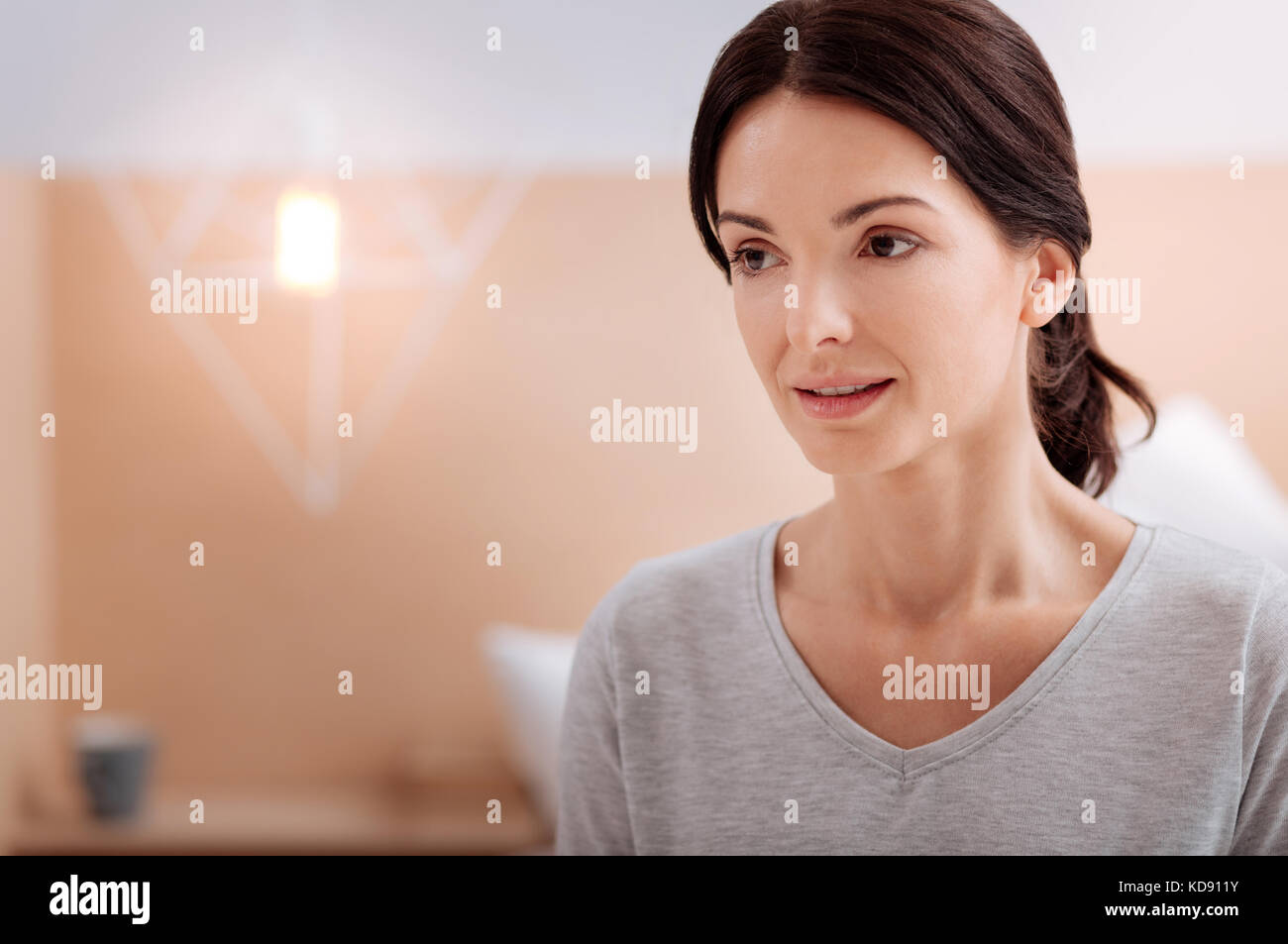 Calma piacevole giovane donna che guarda lontano Foto Stock