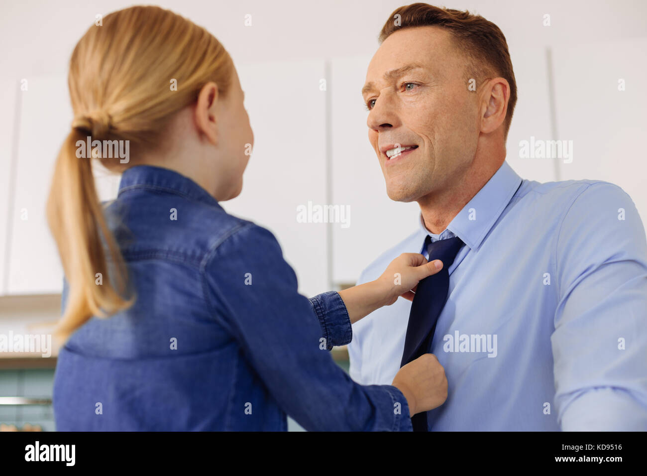 Nice caring figlia tenendo i suoi padri tirante Foto Stock