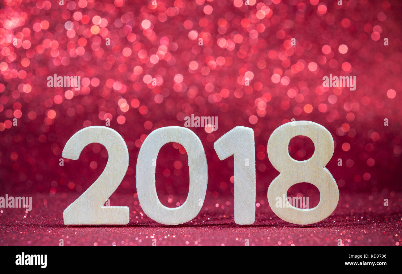 Nuovo anno 2018 bianco numero di legno su carta rossa con luci glitter Foto Stock