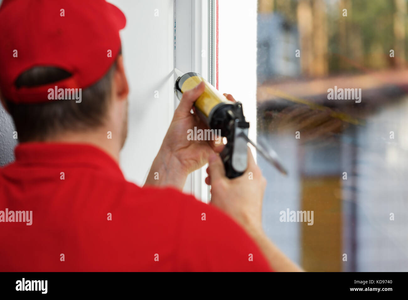 Lavoratore applicando cianfrinare attorno al telaio del finestrino Foto Stock