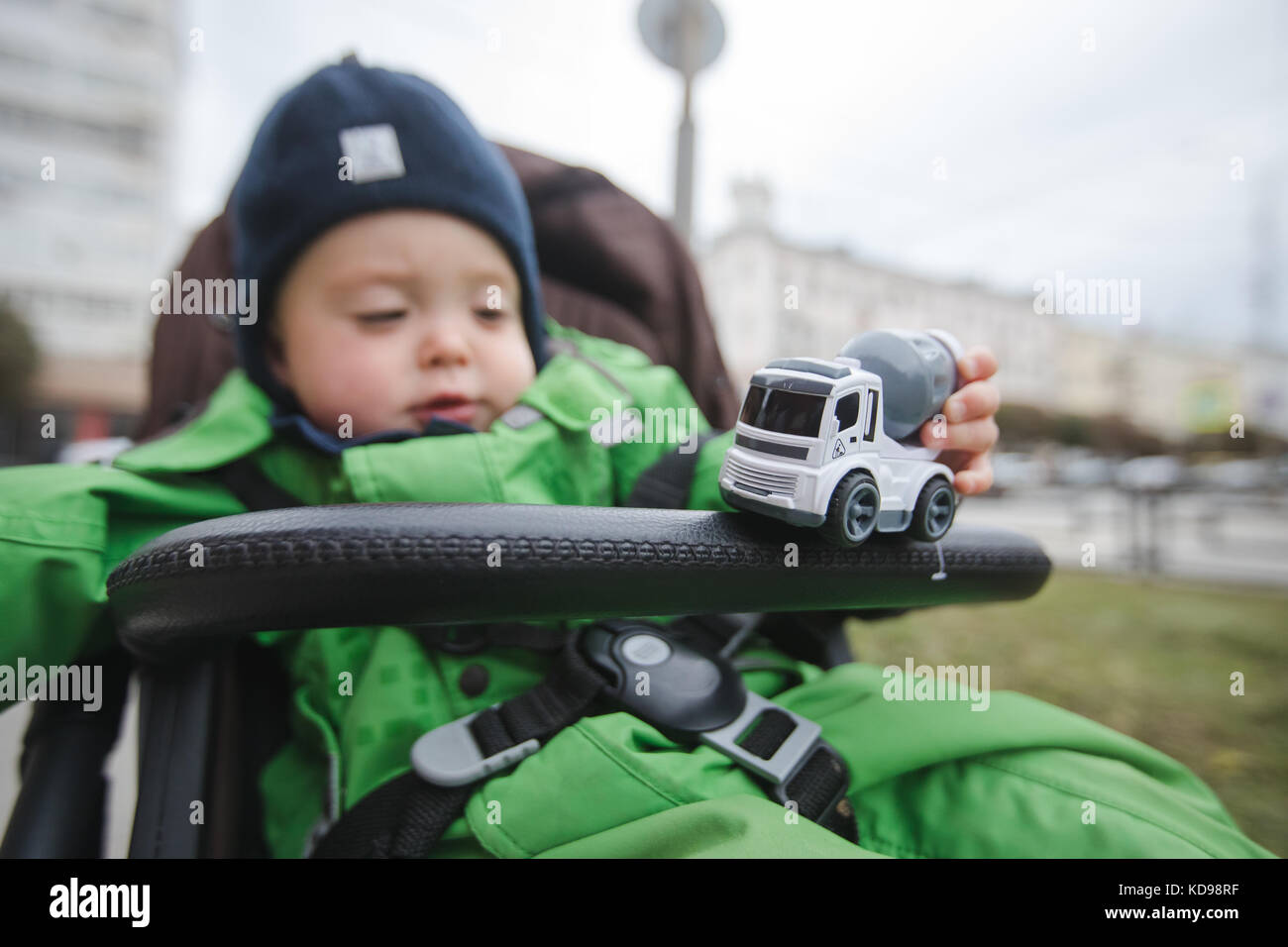 Bambino nel passeggino giocando con auto Foto Stock