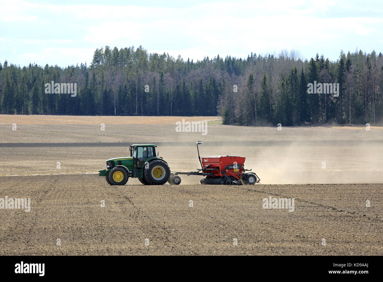 Jokioinen, Finlandia - 7 maggio 2017: paesaggio di campagna finlandese con John Deere trattore 6830 e tume nova combi seminatrice 4000 durante il lavoro sul campo a sp Foto Stock