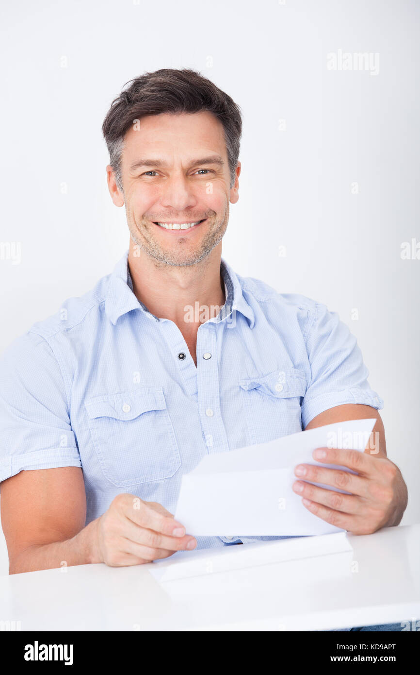 Felice uomo maturo leggendo la carta tenendo in mano Foto Stock