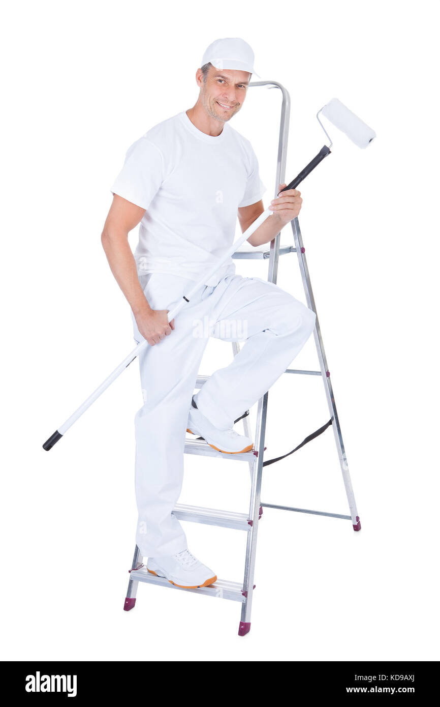 Maschio maturo pittore con rullo di vernice e la scaletta su sfondo bianco Foto Stock
