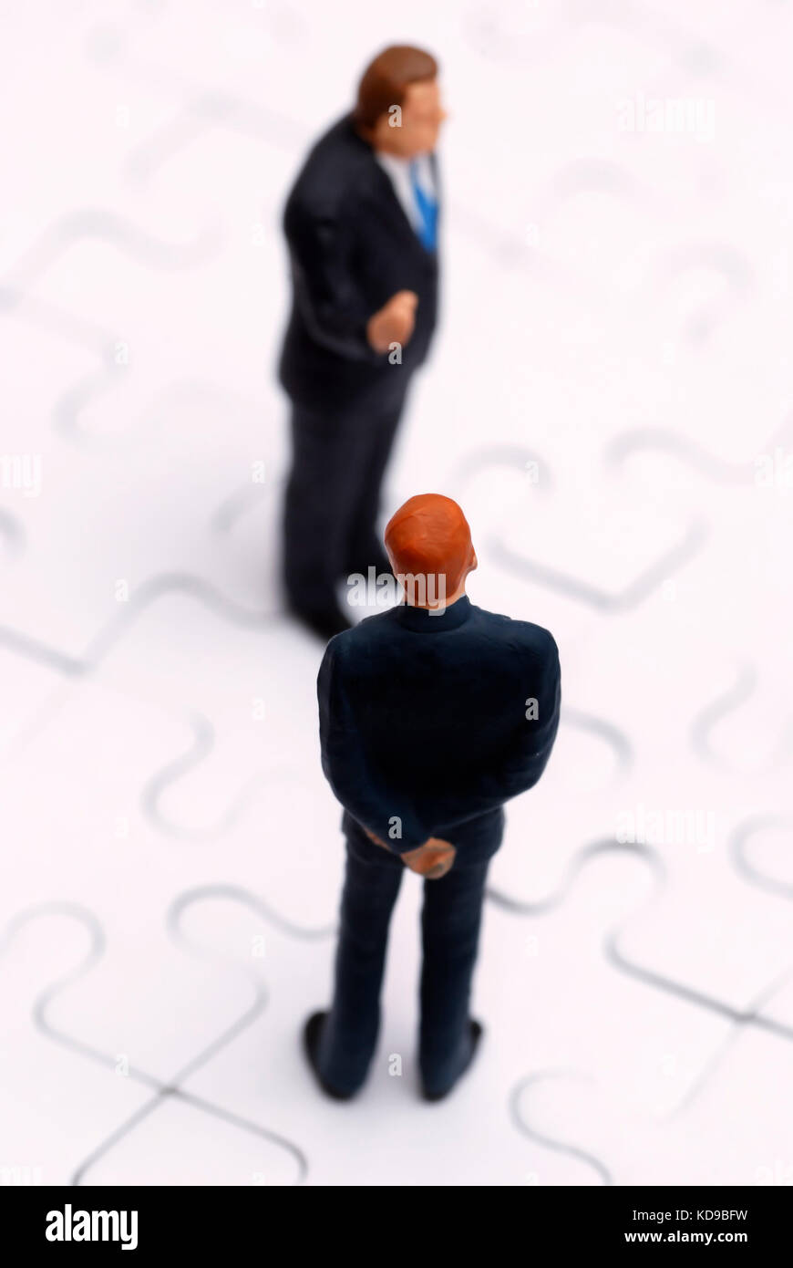 Statuine in miniatura degli imprenditori su un puzzle Foto Stock