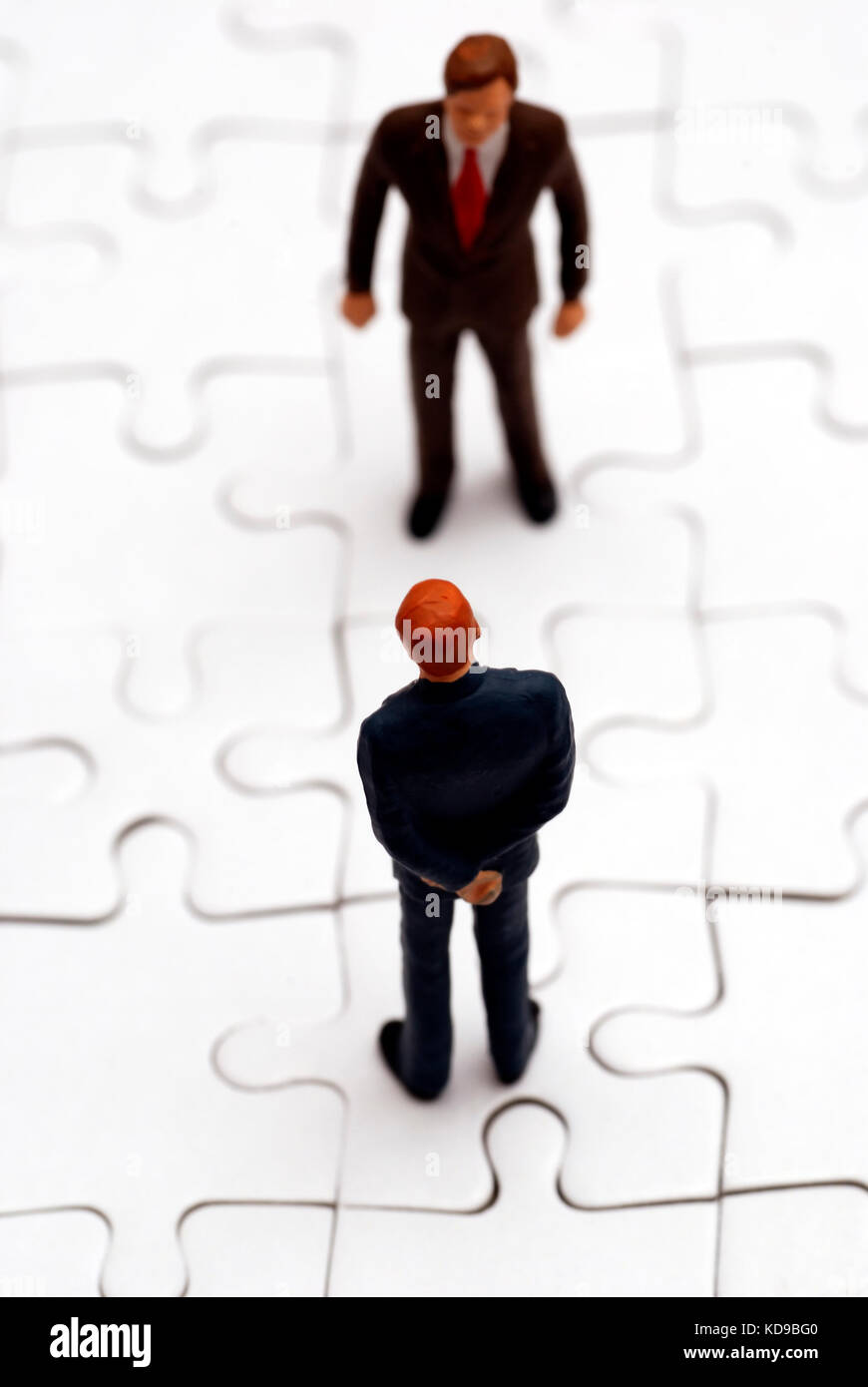 Statuine in miniatura degli imprenditori su un puzzle Foto Stock