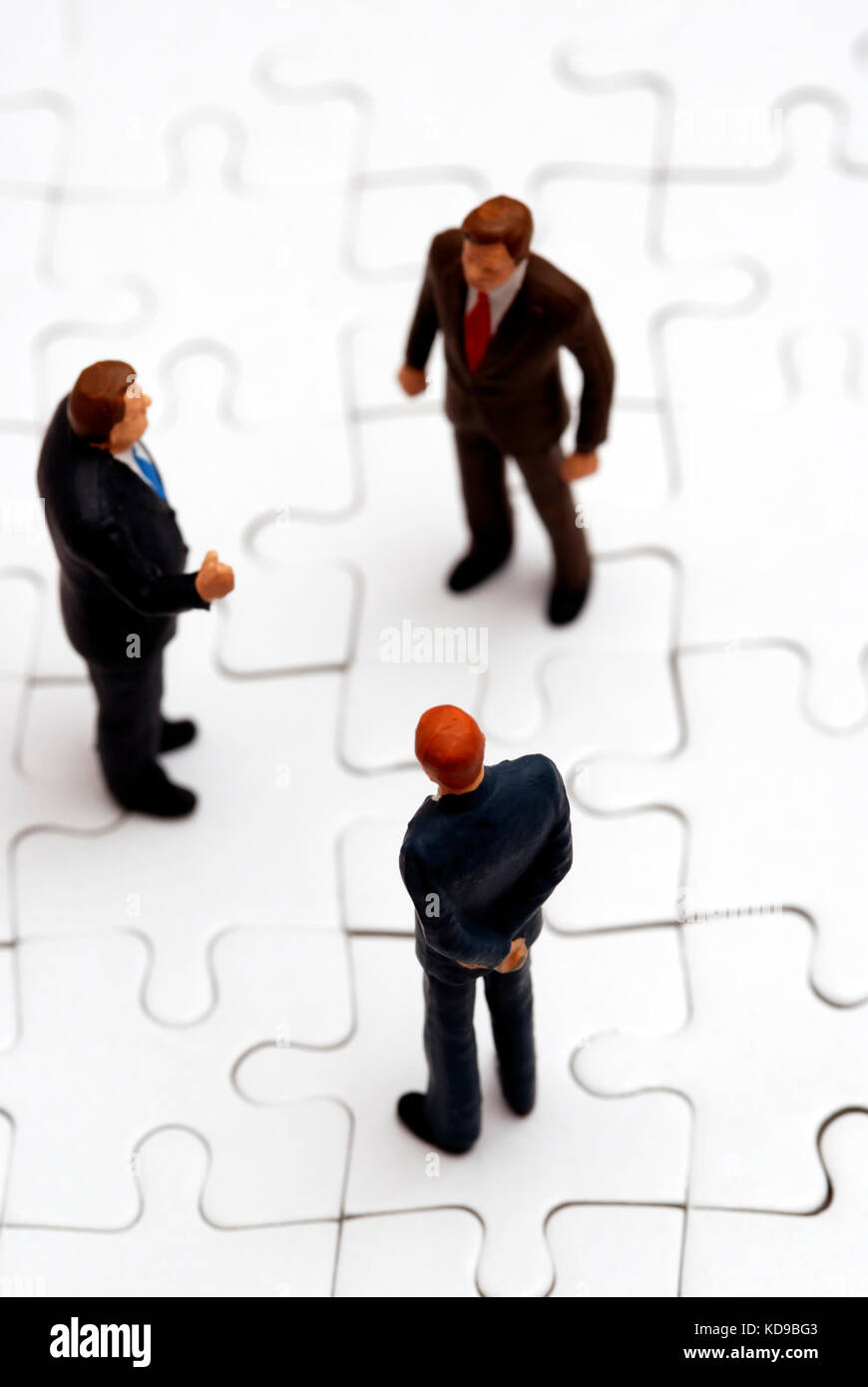Statuine in miniatura degli imprenditori su un puzzle Foto Stock