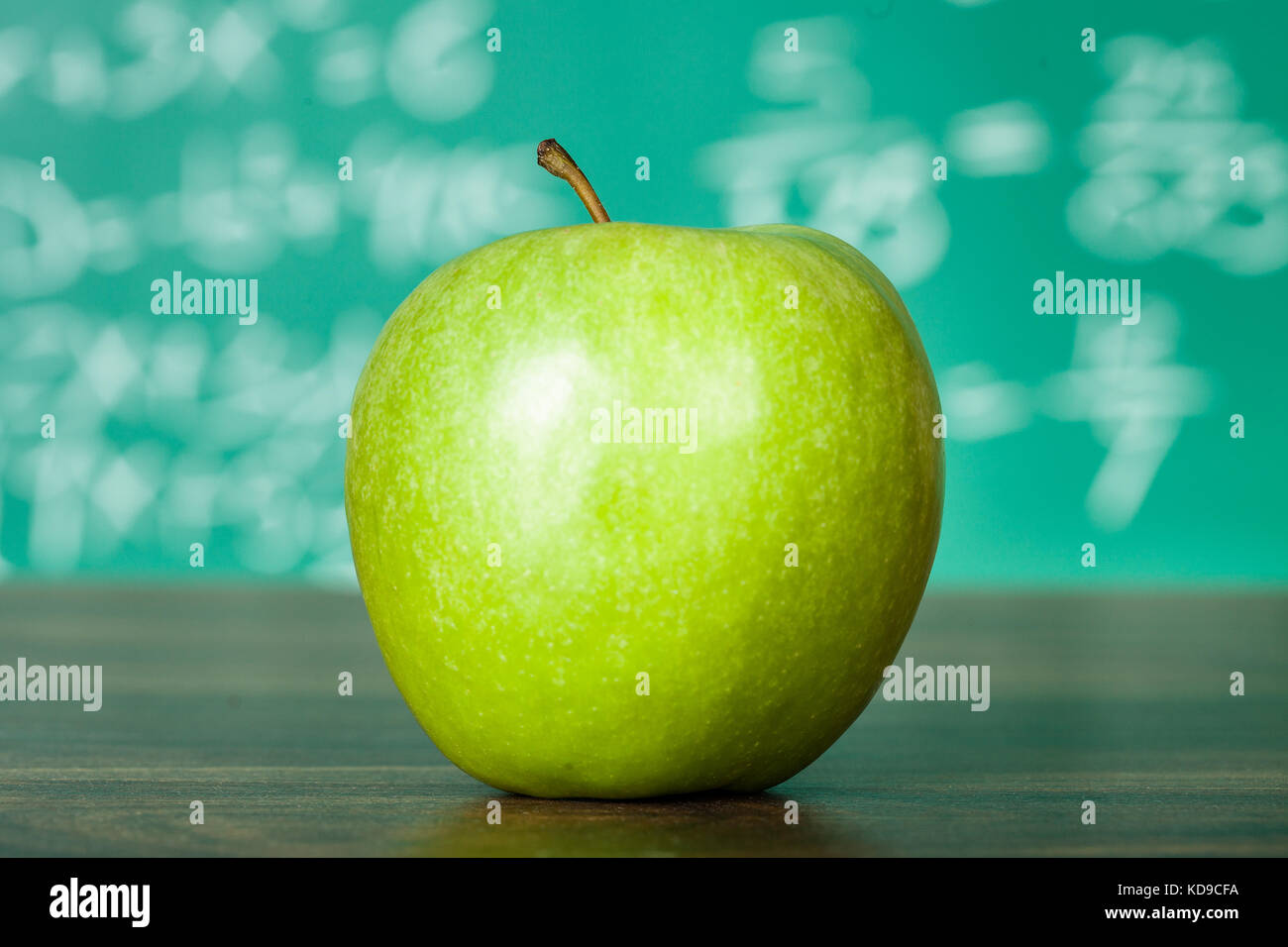Foto di mela verde sul banco di scuola Foto Stock
