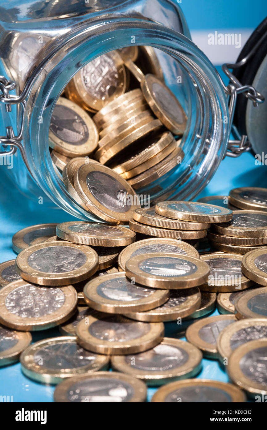 Monete metalliche in euro fuoriuscita da un barattolo di denaro Foto Stock