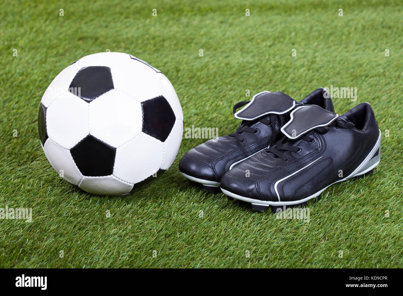 Close-up di calcio e tacchetti sul campo Foto Stock