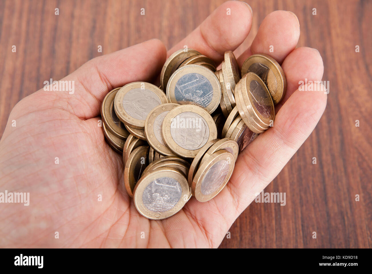Close-up Foto della mano che tiene conio di monete metalliche in euro Foto Stock