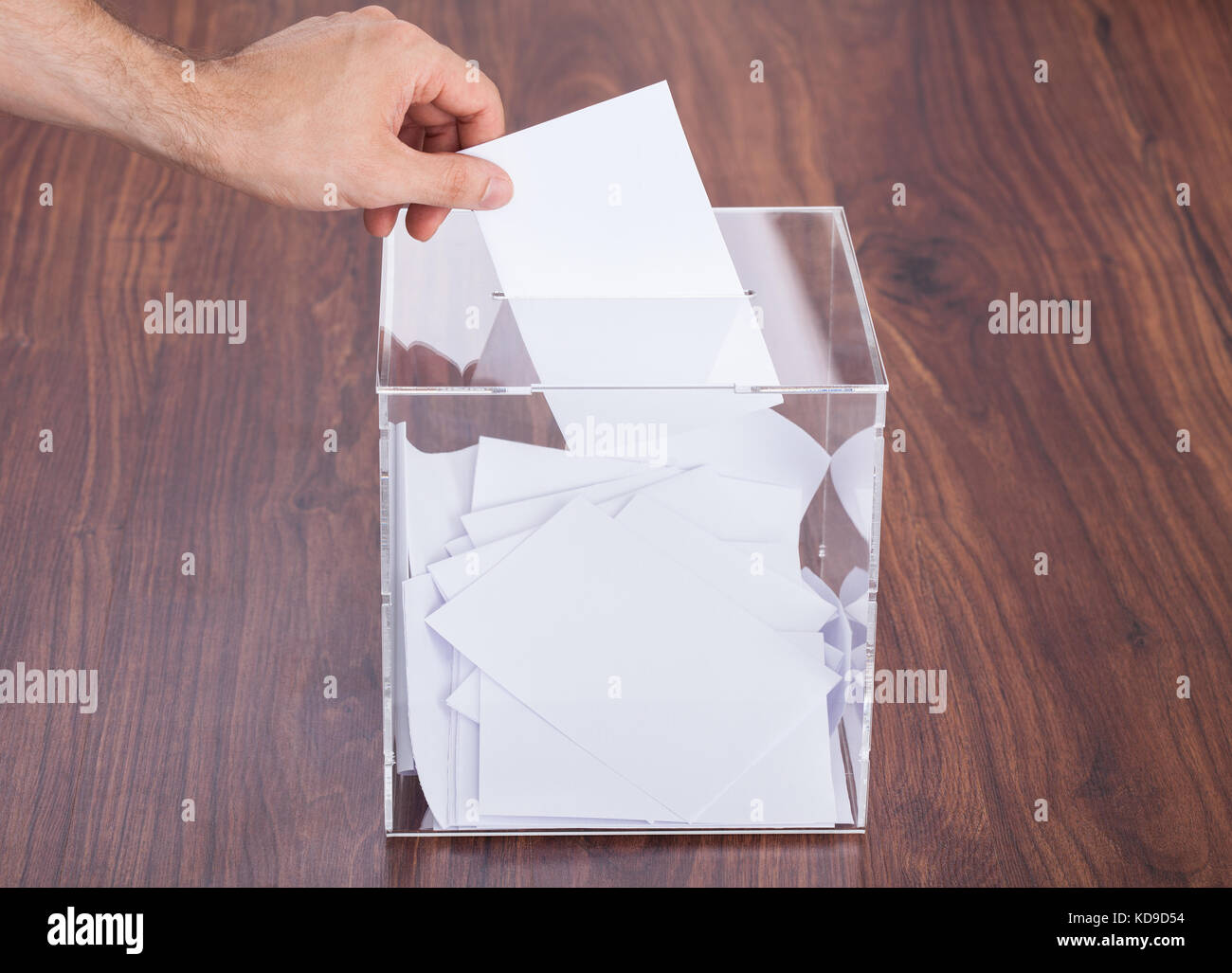 Close-up di persona mano sta mettendo in ballottaggio Box mantenuta su un tavolo di legno Foto Stock