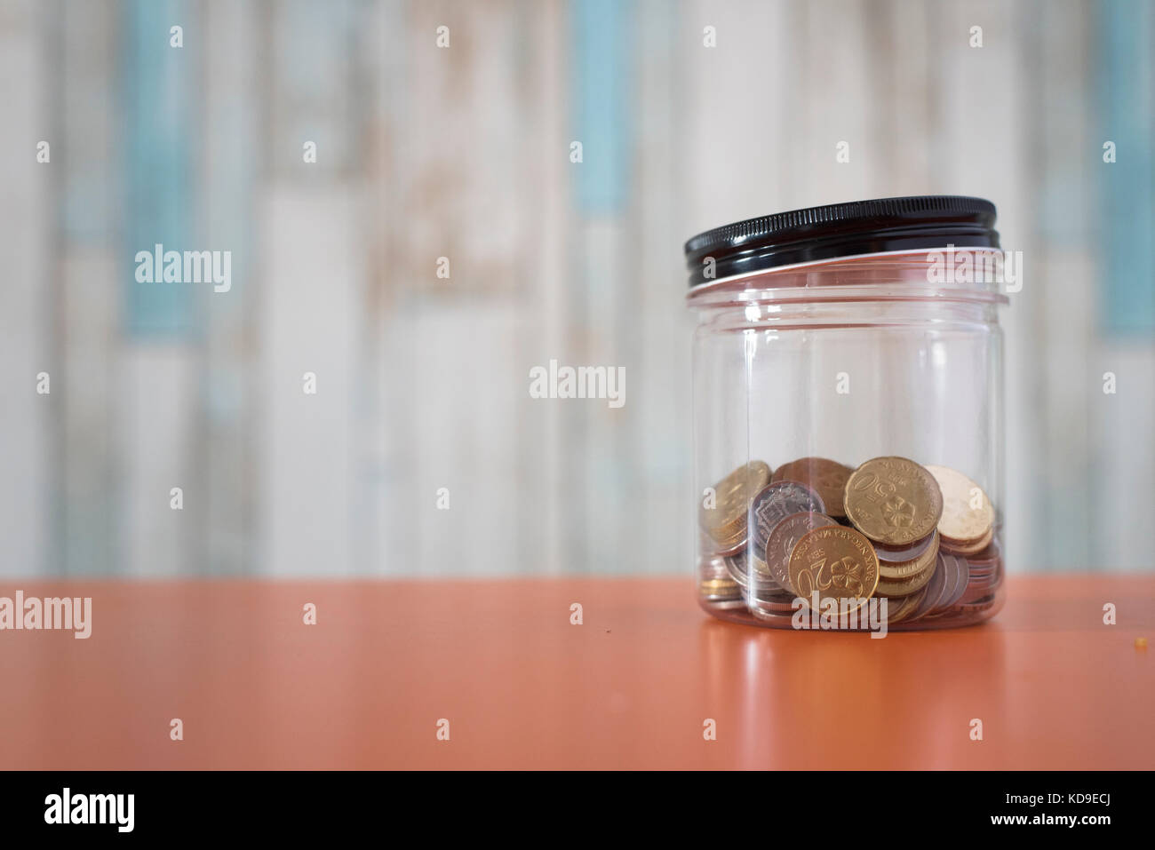 Le monete d'oro in un vaso in plastica. moneta malese. economia e il concetto di risparmio. cash management Foto Stock
