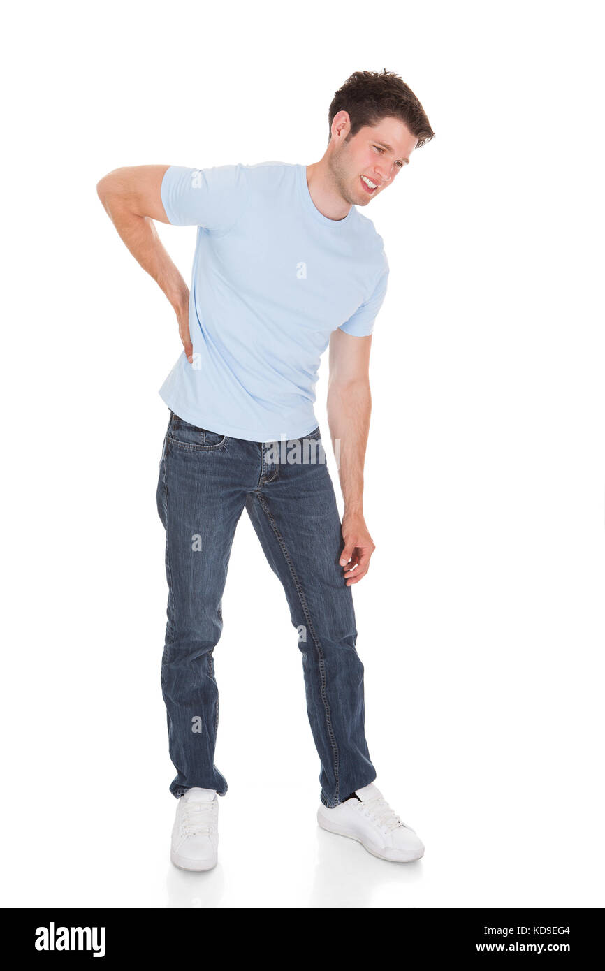 Giovane uomo che soffre di dolori alla schiena isolate su sfondo bianco Foto Stock