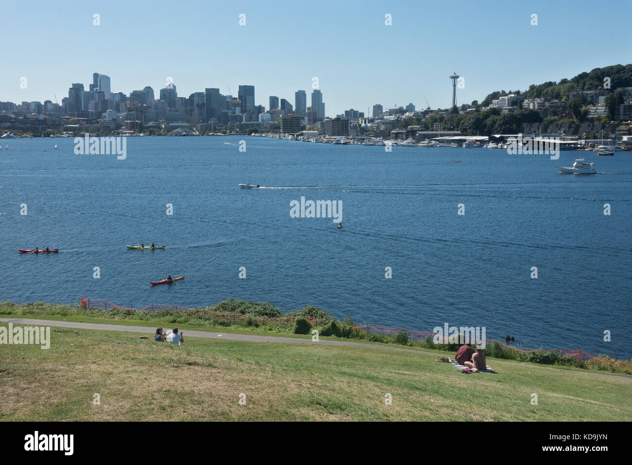 I turisti lounge sulla collina, aka il tumulo - a lavori gas parco affacciato sul pittoresco lago unione, kayakers, Seattle skyline con lo Space Needle. Foto Stock