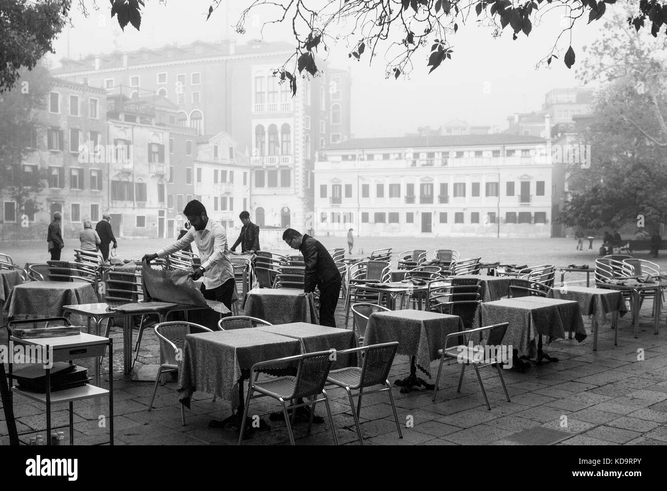 Venezia, Italia. 11 ottobre, 2017. (Foto è stata presa in bianco e nero) lavoratori imposta i tavoli all'esterno durante una giornata di nebbia a venezia, Italia. in questo periodo a Venezia si avvia per la prima volta la nebbia di mattina. © Simone padovani / risveglio / alamy live news Foto Stock